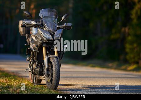 Un moto parcheggio sulla strada sul lato destro e al tramonto, selezionare sfondo di focalizzazione. Foto Stock