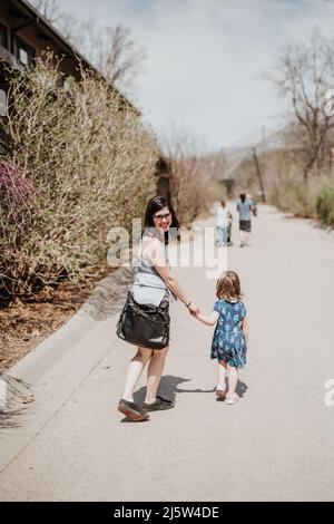 Madre e figlia camminano lungo il marciapiede allo zoo il giorno d'estate Foto Stock