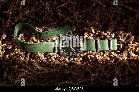 Orologio da uomo vecchio con cinturino in pelle su un ripieno. Evidenziazione Foto Stock