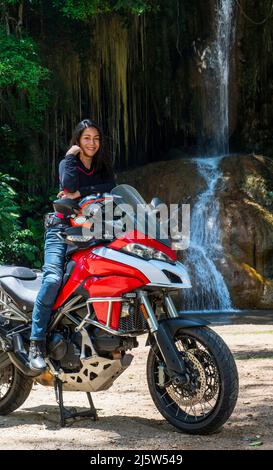 Donna tailandese che riposa sulla sua moto avventura nel nord della Thailandia Foto Stock