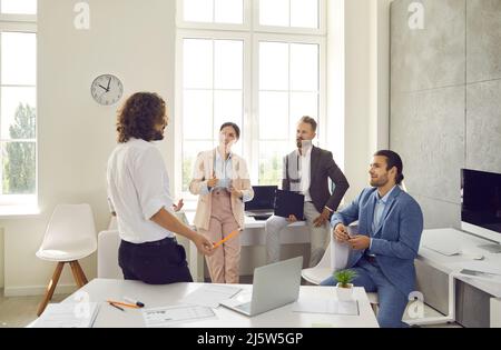 Allenatore maschile fare la presentazione per diversi impiegati d'ufficio Foto Stock