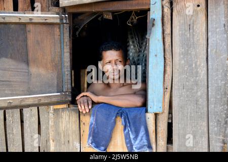 Una famiglia malgascia che guarda fuori la loro finestra di casa. Regione di Ambohimanga, Madagascar. Foto Stock