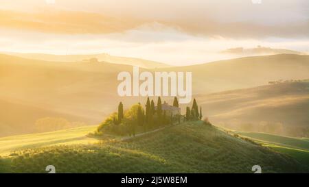 ITALIA, TOSCANA, SAN QUIRICO D'ORCIA - Podere Belvedere Agriturismo all'alba con vista sulle colline della Val d'Orcia. Foto Stock