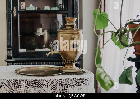 Samovar russo su un tavolo con una tovaglia, sullo sfondo di una dispensa Foto Stock