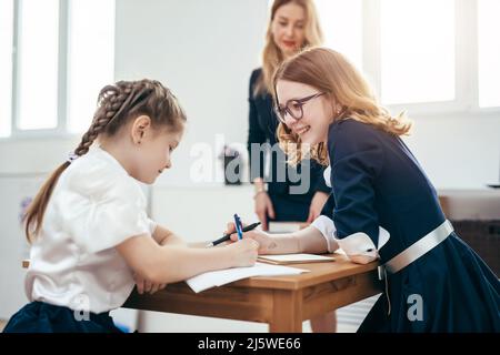 Ritratto di scolaresche che parlano durante la lezione in aula. Foto Stock