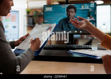 Manager donne che lavorano alla domanda di assunzione discutere il curriculum vitae con reclutatore remoto durante la conferenza di videoconferenza on-line in startup Office. Chiamata di teleconferenza sullo schermo del computer Foto Stock