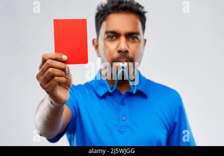 Arbitro indiano fischio e che mostra la scheda rossa Foto Stock