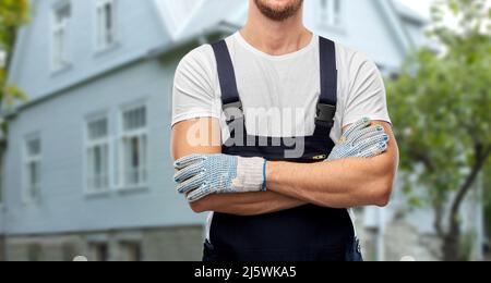 primo piano del costruttore maschile in tuta e guanti Foto Stock