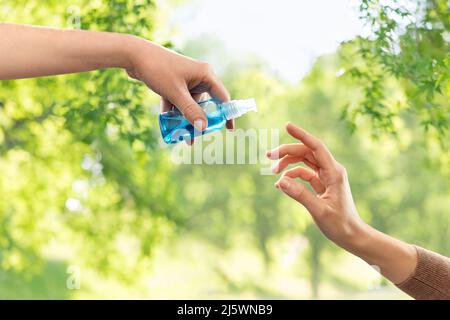 il primo piano delle mani si dona l'igienizzante per gel Foto Stock