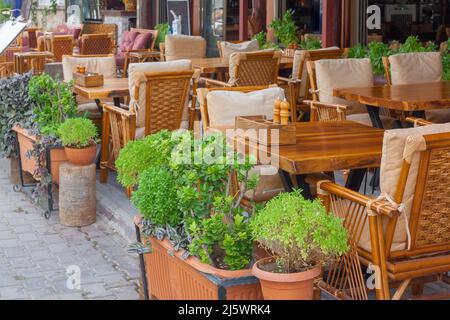 Tavoli e sedie enormi in legno con cuscini nel caffè. Foto orizzontale. Foto Stock