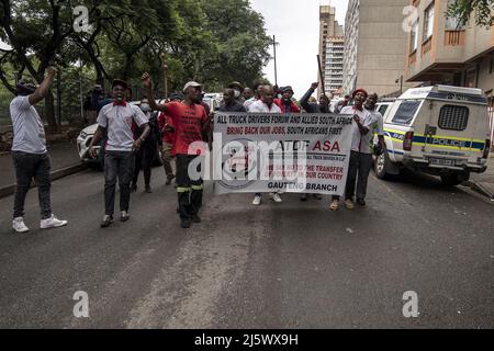 19 febbraio 2022, Sudafrica, Johannesburg: I membri dell'All Truck Drivers Forum, che sostiene la concessione di posti di lavoro per i conducenti di autocarri solo ai sudafricani, dimostrano il loro sostegno all'operazione Dududula in una marcia nel distretto di Hillbrow. Gruppi di vigilanti come 'operazione Dudula' stanno causando un'agitazione nel paese. Fondato nel comune di Johannesburg di Soweto, il gruppo sta godendo di crescente simpatia in tutto il paese. I loro sostenitori prendono ripetutamente la legge nelle loro proprie mani - per esempio, quando chiedono che i proprietari di deposito mostrino i permessi di lavoro dei loro impiegati o espellano i piccoli stranieri Foto Stock