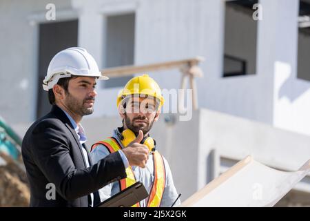 L'uomo d'affari o boss dà il consulente per l'ingegnere, sono consulenza e la risoluzione dei problemi nella costruzione del sito di pianificazione per la nuova casa. Foto Stock