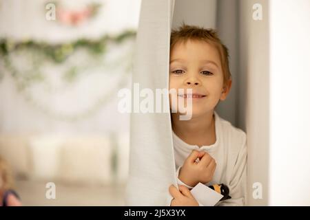 Bambino carino a casa con piccoli pulcini neonato, godendo, ragazzo carino e amico animale in una stanza soleggiata Foto Stock