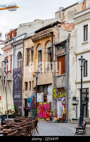 Scendi lungo la strada laterale con graffiti sulle pareti di edifici fatiscenti nel centro di Bucarest, capitale della Romania, Europa centrale Foto Stock