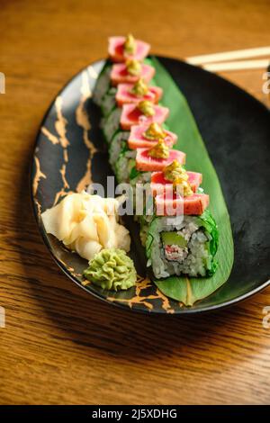 Un set di sushi freschi con salmone, avocado e semi di sesamo nero da vicino. Fuoco selettivo Foto Stock