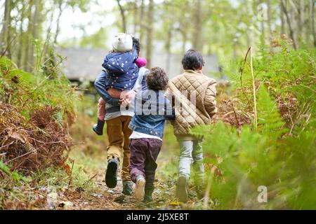 Fratelli e sorelle che camminano sul sentiero in boschi Foto Stock