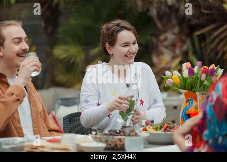 Felice coppia giovane che si gode pranzo al tavolo del patio Foto Stock