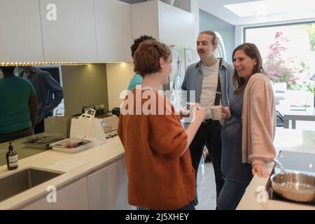 Amici di coppia che parlano e bevono il tè in cucina Foto Stock