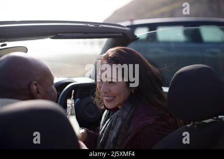 Felice coppia bere soda in convertibile Foto Stock