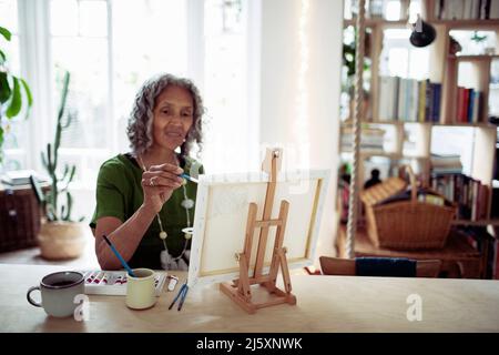Pittura donna anziana a easel Foto Stock