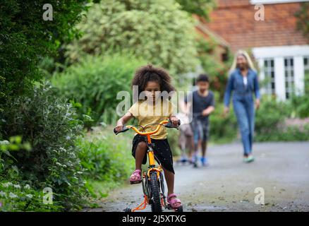 Ragazza che va in bicicletta in vialetto Foto Stock