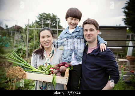 Ritratto famiglia felice con verdure raccolte in giardino Foto Stock