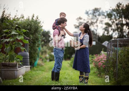 Famiglia felice in giardino cortile Foto Stock