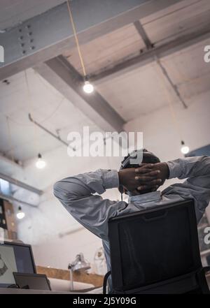 Uomo d'affari reclinato con le mani dietro la testa Foto Stock