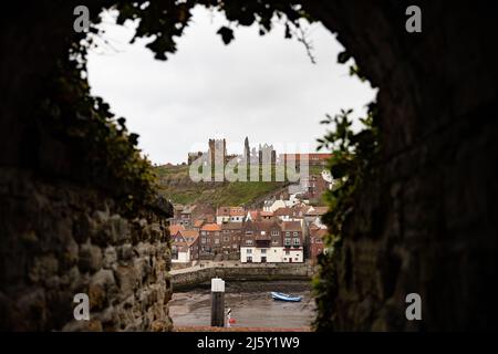 WHITBY, INGHILTERRA. Aprile 25th 2022. Whitby Abbey è vista su una collina attraverso un tunnel fino a una scorciatoia a Whitby nel weekend del Goth. Foto Stock