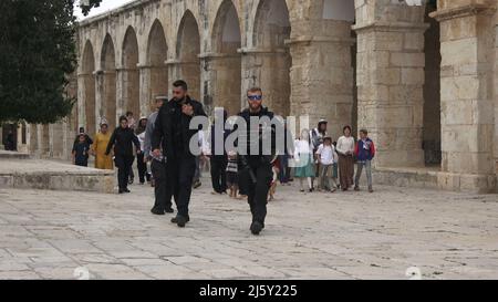 I poliziotti israeliani scortano un gruppo di ebrei religiosi che visitano il Monte del Tempio noto ai musulmani come Haram esh-Sharif (Santuario del Nobile) durante la festa di Pesach Ebraico (Pasqua) nella città vecchia il 20 aprile 2022 a Gerusalemme, Israele. Ebrei, cristiani e musulmani celebrano la Pasqua di quest'anno e il Ramadan nella stessa settimana, che ha causato tensioni tra palestinesi e israeliani, specialmente a Gerusalemme. Foto Stock