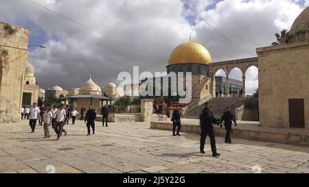 I poliziotti israeliani scortano un gruppo di ebrei religiosi che visitano il Monte del Tempio noto ai musulmani come Haram esh-Sharif (Santuario del Nobile) durante la festa di Pesach Ebraico (Pasqua) nella città vecchia il 20 aprile 2022 a Gerusalemme, Israele. Ebrei, cristiani e musulmani celebrano la Pasqua di quest'anno e il Ramadan nella stessa settimana, che ha causato tensioni tra palestinesi e israeliani, specialmente a Gerusalemme. Foto Stock