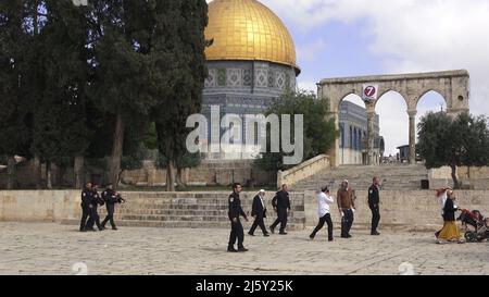 I poliziotti israeliani scortano un gruppo di ebrei religiosi che visitano il Monte del Tempio noto ai musulmani come Haram esh-Sharif (Santuario del Nobile) durante la festa di Pesach Ebraico (Pasqua) nella città vecchia il 20 aprile 2022 a Gerusalemme, Israele. Ebrei, cristiani e musulmani celebrano la Pasqua di quest'anno e il Ramadan nella stessa settimana, che ha causato tensioni tra palestinesi e israeliani, specialmente a Gerusalemme. Foto Stock