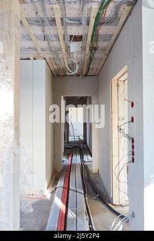 Corridoio o corridoio come cantiere per la costruzione di case in nuovo edificio con cavi e tubi Foto Stock