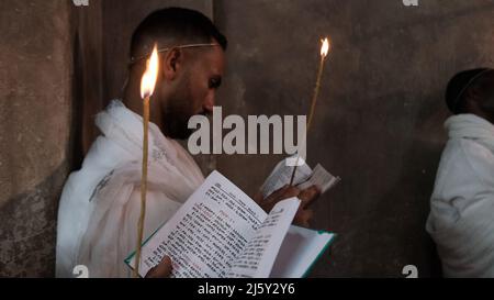 I cristiani ortodossi etiopi tengono candele mentre prendono parte alla cerimonia del fuoco Santo nel monastero di Deir El-Sultan adiacente alla Chiesa del Santo Sepolcro il 23 aprile 2022 a Gerusalemme, Israele. I cristiani etiopi commemorano gli eventi attorno alla crocifissione di Gesù Cristo, portando alla sua risurrezione nella Pasqua, che in lingua amarica viene chiamata Fasika. Foto Stock