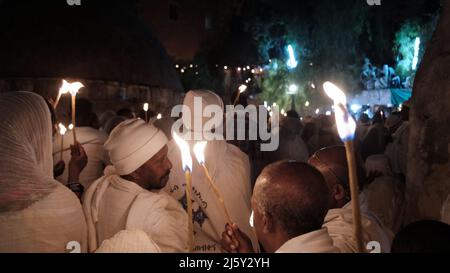 I cristiani ortodossi etiopi tengono candele mentre prendono parte alla cerimonia del fuoco Santo nel monastero di Deir El-Sultan adiacente alla Chiesa del Santo Sepolcro il 23 aprile 2022 a Gerusalemme, Israele. I cristiani etiopi commemorano gli eventi attorno alla crocifissione di Gesù Cristo, portando alla sua risurrezione nella Pasqua, che in lingua amarica viene chiamata Fasika. Foto Stock