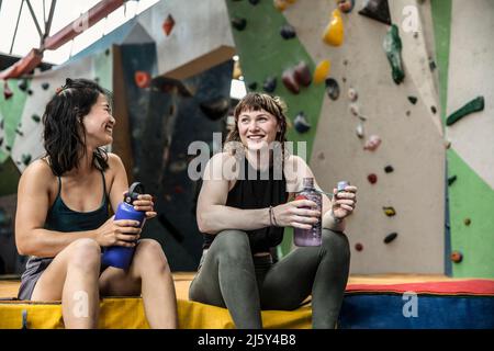 Buone arrampicatrici di roccia femminili che prendono una pausa alla palestra di arrampicata Foto Stock