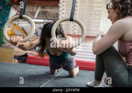 Allenamenti di scalatori di roccia femminile in palestra di arrampicata Foto Stock