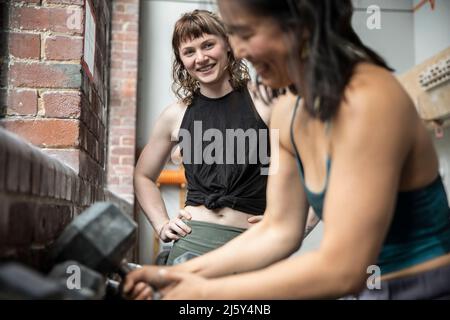 Sorridenti amici donne che si allenano in palestra Foto Stock