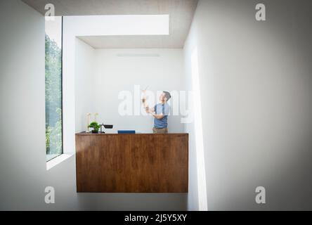 Ingegnere maschile che ispeziona il modello di turbina eolica in ufficio Foto Stock