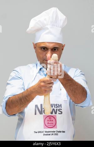 Il Segretario per la Salute Sajid Javid che forma il pane sfidante mentre partecipa a un'attività di cottura di Challah ospitata dal capo Rabbi Ephraim Mirvis come parte del suo progetto Shabbat UK, presso la Sinagoga Centrale unita di Londra. Data foto: Martedì 26 aprile 2022. Foto Stock