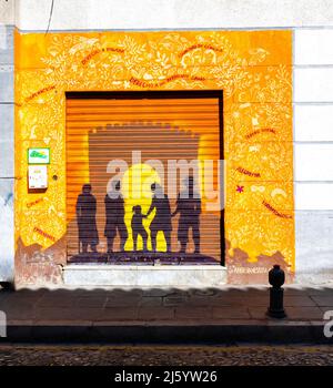 Murale sulla porta a bordo di ASPA - Asociacion Andaluza por la Solidaridad y la Paz, raffigurante silhoutte di famiglia e il Sole Granada, Spagna Foto Stock