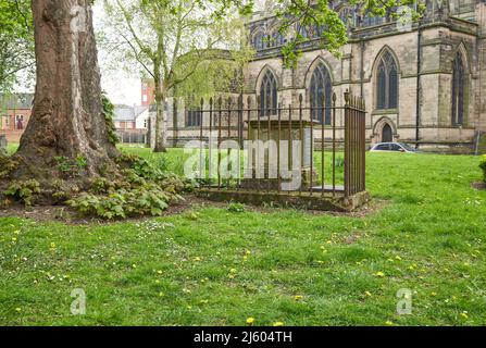 Piccola tomba racchiusa in vecchio ferro recinzione in un cantiere di chiesa a Loughborough, Leicestershire, Regno Unito Foto Stock