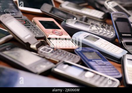 KHARKIV, UCRAINA - 16 DICEMBRE 2021: Alcuni vecchi hanno usato i telefoni cellulari obsoleti dal 90s-2000s periodo. Riciclare l'elettronica nel mercato a buon mercato Foto Stock