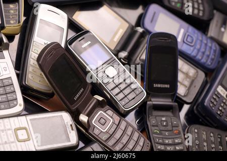 KHARKIV, UCRAINA - 16 DICEMBRE 2021: Alcuni vecchi hanno usato i telefoni cellulari obsoleti dal 90s-2000s periodo. Riciclare l'elettronica nel mercato a buon mercato Foto Stock