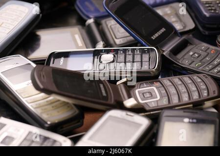 KHARKIV, UCRAINA - 16 DICEMBRE 2021: Alcuni vecchi hanno usato i telefoni cellulari obsoleti dal 90s-2000s periodo. Riciclare l'elettronica nel mercato a buon mercato Foto Stock