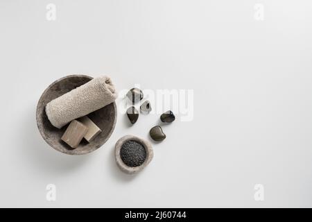 Asciugamano e saponi con sali da bagno rilassanti su sfondo bianco, con spazio per testo e grafica. Foto Stock