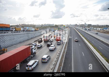 Nairobi, Kenya. 26th Apr 2022. Un'auto percorre la nuova sezione della superstrada di Nairobi mentre durante l'ora di punta si verifica un traffico intenso sulla strada senza pedaggio lungo la strada di Mombasa. I lavori finali proseguono sulla costruzione dell'autostrada a pedaggio lunga 27,1km, la Nairobi Expressway è prevista per il giugno 2022. La superstrada di Nairobi è destinata a decongestionare la città di Nairobi. (Foto di Boniface Muthoni/SOPA Images/Sipa USA) Credit: Sipa USA/Alamy Live News Foto Stock