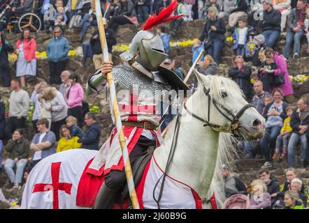 Un cavaliere a cavallo porta un palo da giostra indossando un'armatura per il corpo durante il Grand Medieval Joust al Castello di Tamworth il giorno di San Giorgio. Foto Stock