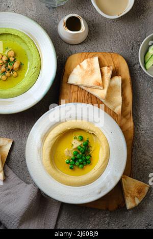 Hummus tradizionale con piselli di neve e ceci, con acqua e verdure fresche Foto Stock