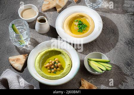 Hommos tradizionali con piselli da neve e ceci, con acqua e verdure fresche Foto Stock